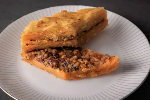 Traditional Albanian baklava slice made with layered phyllo pastry, walnuts, and sweet syrup