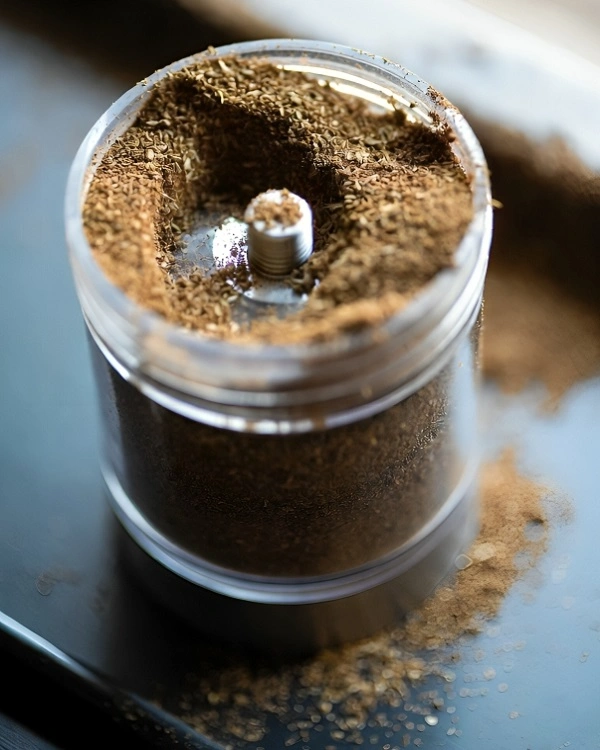 Freshly ground garam masala in a spice grinder close-up