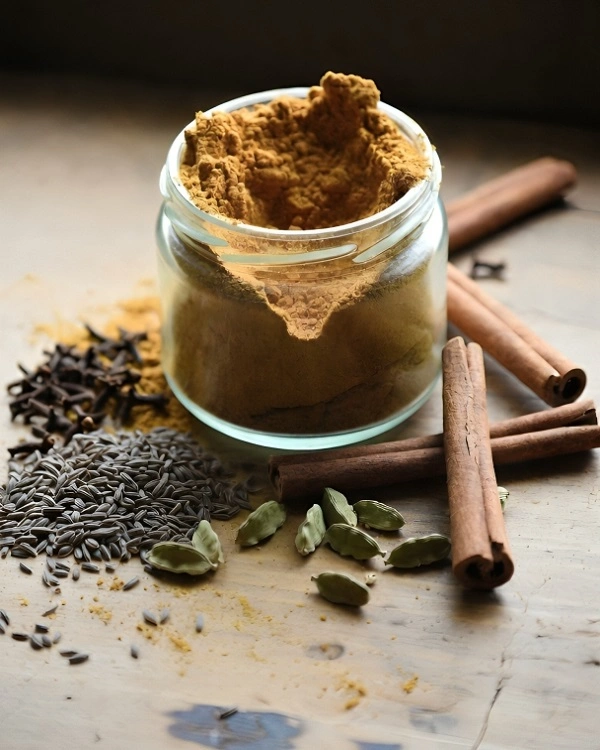 Homemade garam masala powder stored in a glass jar