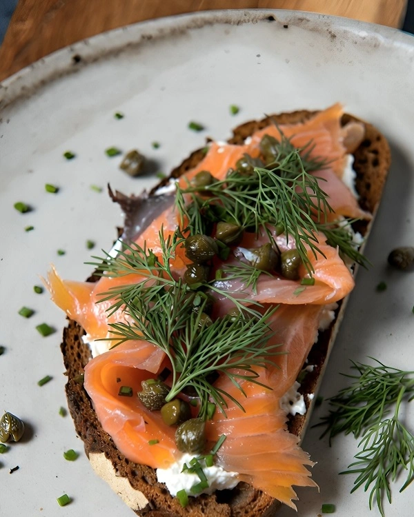 Open-faced sandwich made with a slice of dark Borodinsky bread, cream cheese, smoked salmon, and fresh dill.
