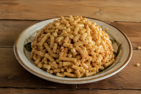 A mound of sweet Chak-Chak dessert made from golden fried dough sticks bound together with shiny honey glaze