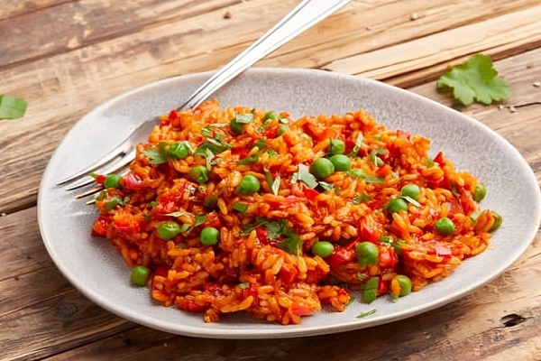 Djuvec rice served on a plate with bell peppers, peas, and tomatoes – traditional Balkan one-pot rice dish