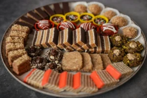 Traditional Serbian desserts sweet table with baklava, sitni kolači, layered cakes, and assorted cookies served on a festive platter