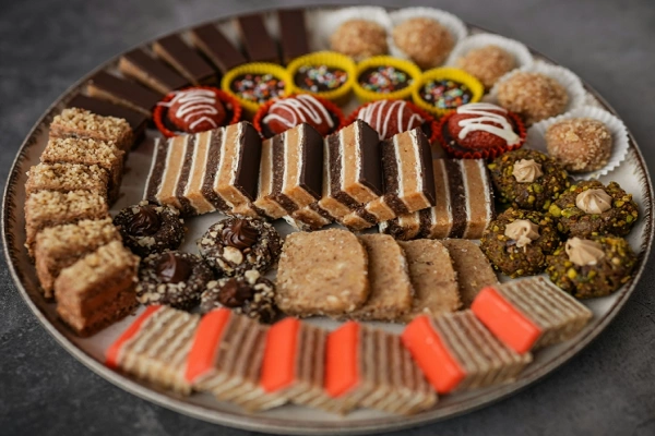 Traditional Serbian desserts sweet table with baklava, sitni kolači, layered cakes, and assorted cookies served on a festive platter