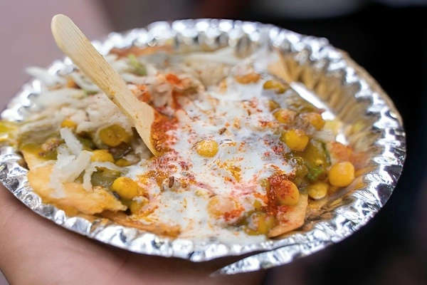 spicy aloo chaat served in foil plate with yogurt chutney chickpeas and crispy potatoes street style snack