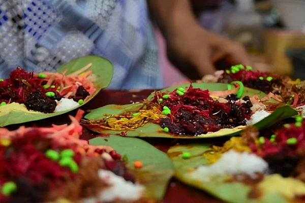 Meetha paan ingredients arranged on fresh betel leaves before folding at a traditional paan preparation setup