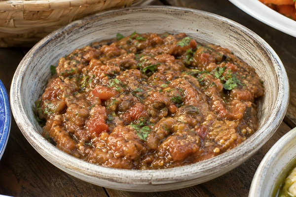Moroccan zaalouk eggplant and tomato salad served in a rustic bowl with herbs and olive oil