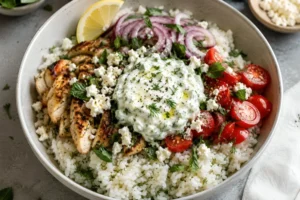 Easy tzatziki rice recipe bowl with Greek yogurt sauce, halloumi, rice, and Mediterranean toppings