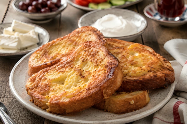 Bukë me Vezë (Albanian bread with eggs) served with feta cheese, yogurt, olives, and fresh vegetables