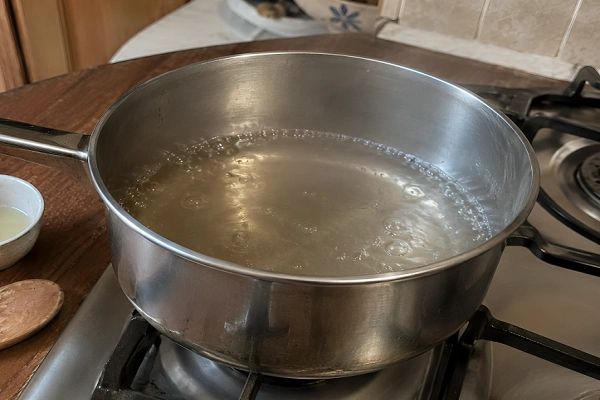 Sugar syrup gently bubbling in a stainless steel saucepan on the stove