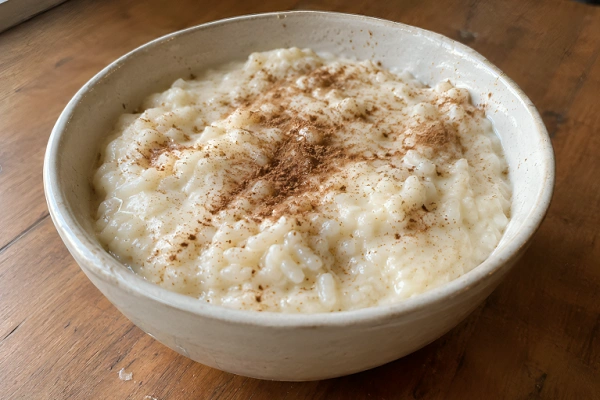 Creamy Albanian Sultjash rice pudding served in a ceramic bowl topped with ground cinnamon.