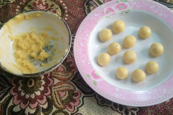 Small smooth ras malai dough balls arranged on a pink floral plate